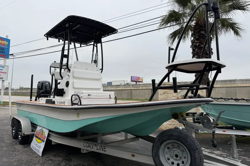 Slide: The Image of 2017 Shallow Sport 24 Sport boat on trailer, parked outdoors near palm tree. - 7
