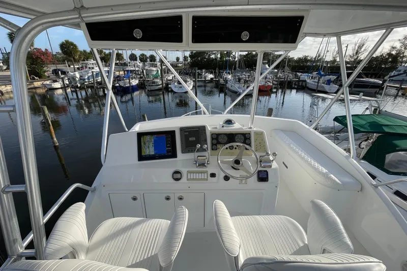 Slide: The Image of Helm of 2003 Egg Harbor 37 Sport Fisher with marina view, featuring navigation equipment. - 11