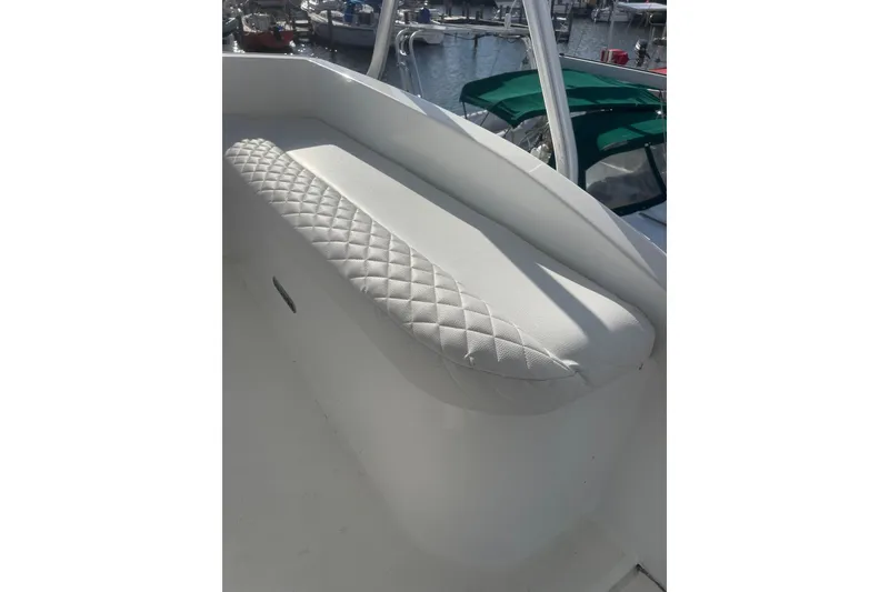 Slide: The Image of White cushioned seating on 2003 Egg Harbor 37 Sport Fisher boat, docked at marina. - 15