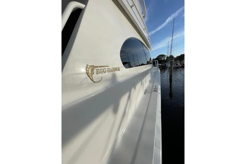 Slide: The Image of 2003 Egg Harbor 37 Sport Fisher yacht docked, showcasing sleek design and logo. - 16