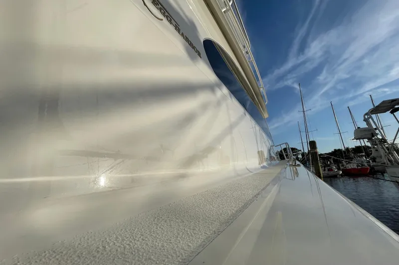 Slide: The Image of 2003 Egg Harbor 37 Sport Fisher yacht reflecting sunlight at marina, clear blue sky. - 18