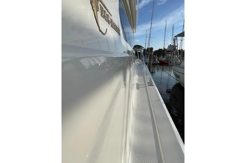 Slide: The Image of 2003 Egg Harbor 37 Sport Fisher yacht docked, reflecting sunlight on calm water. - 23