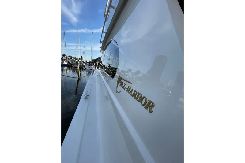 Slide: The Image of 2003 Egg Harbor 37 Sport Fisher yacht docked at marina, reflecting blue sky and boats. - 27