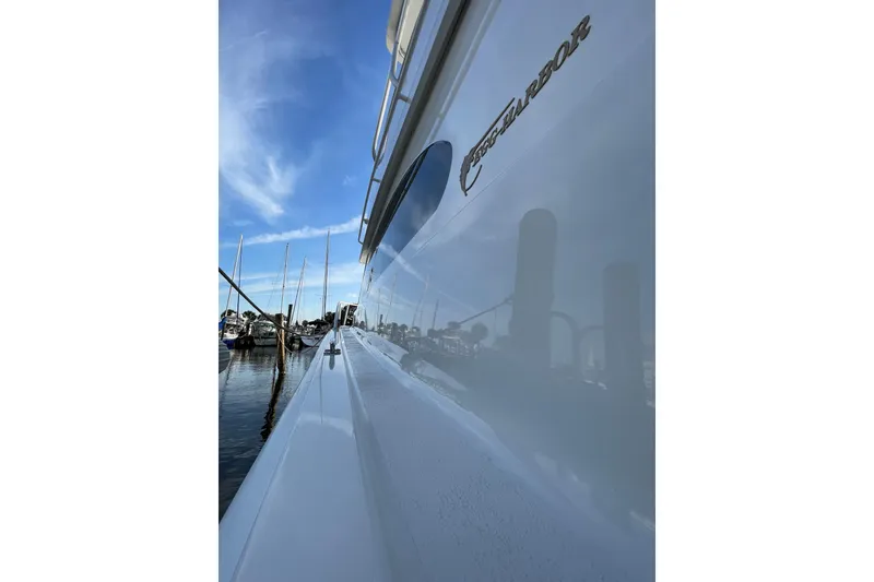 Slide: The Image of 2003 Egg Harbor 37 Sport Fisher boat docked, reflecting clear blue sky and marina. - 28
