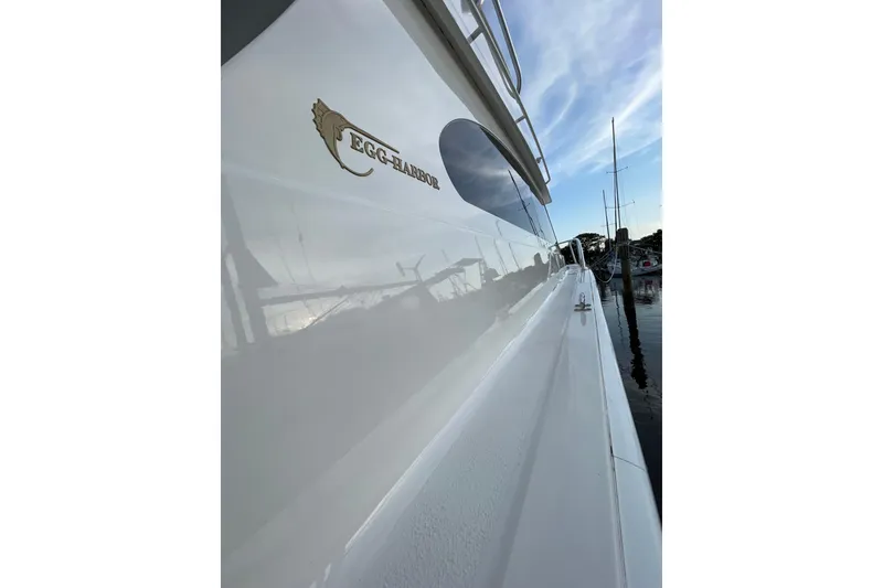 Slide: The Image of 2003 Egg Harbor 37 Sport Fisher boat docked, showcasing sleek design and logo. - 35