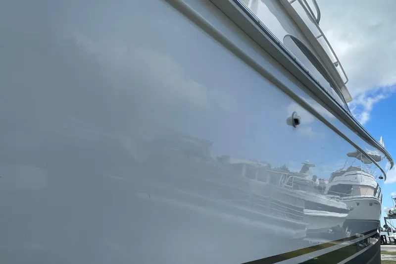 Slide: The Image of 2003 Egg Harbor 37 Sport Fisher yacht reflecting marina scene, clear sky above. - 8