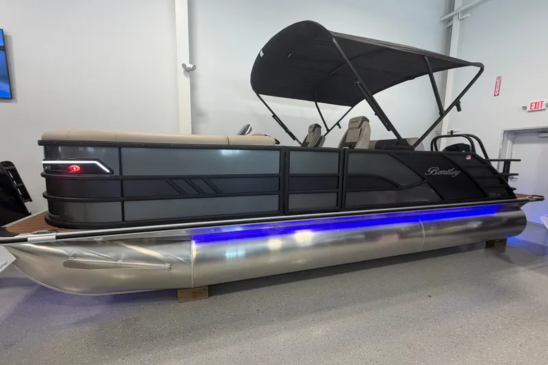 Slide: The Image of 2026 Bentley Pontoons Elite 223 Swingback with sleek design and blue underglow lighting. - 2