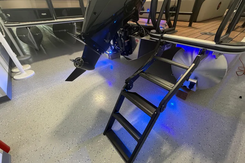 Slide: The Image of 2026 Bentley Pontoons Elite 223 Swingback with motor and ladder, illuminated in blue. - 7