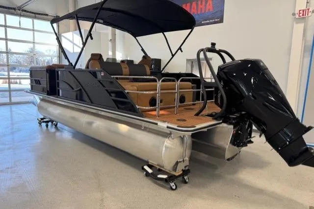 Slide: The Image of 2026 Bentley Pontoons Elite 223 Swingback in showroom, featuring sleek design and powerful outboard motor. - 2