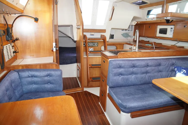 Slide: The Image of Interior of 2000 Catalina 36 MkII sailboat with blue seating and wooden cabinetry. - 25
