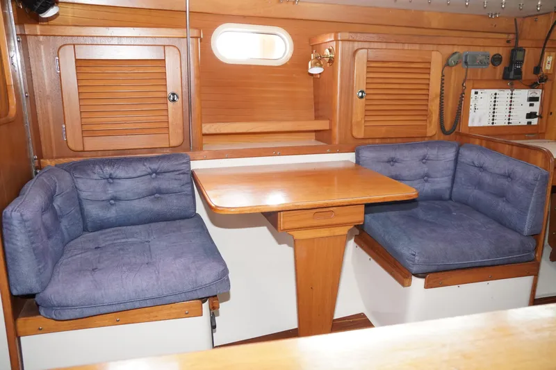 Slide: The Image of Interior of 2000 Catalina 36 MkII sailboat with wooden table and cushioned seating. - 27