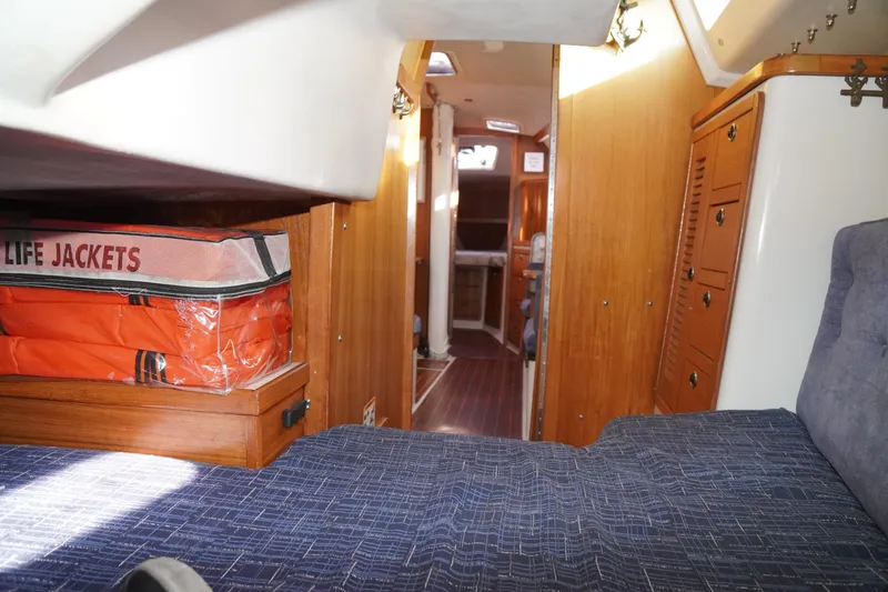 Slide: The Image of Interior of 2000 Catalina 36 MkII sailboat with life jackets and wooden cabinetry. - 36