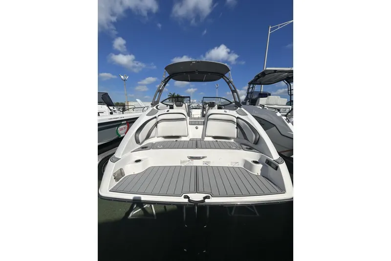 Slide: The Image of 2019 Yamaha AR-240 boat with sleek design, spacious deck, and modern features under a clear sky. - 12