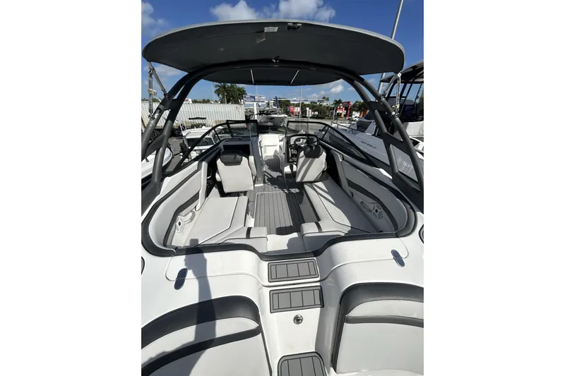 Slide: The Image of 2019 Yamaha AR-240 boat interior with seating and steering, under a clear blue sky. - 13