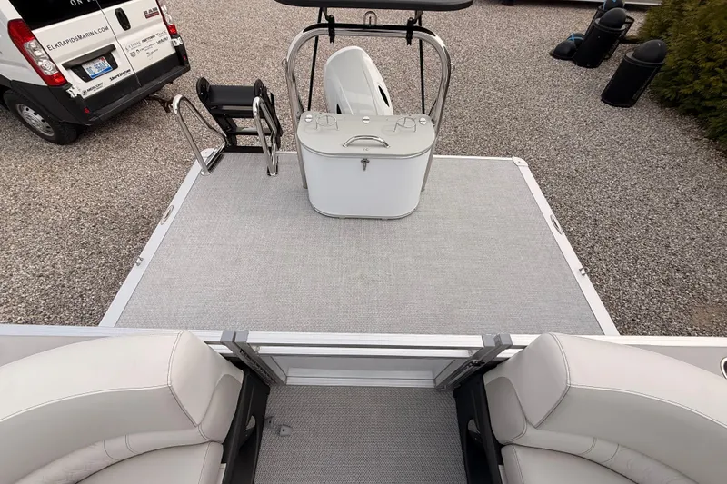 Slide: The Image of 2026 Tahoe Pontoon LTZ Quad Lounger with spacious deck and seating, parked on gravel. - 12