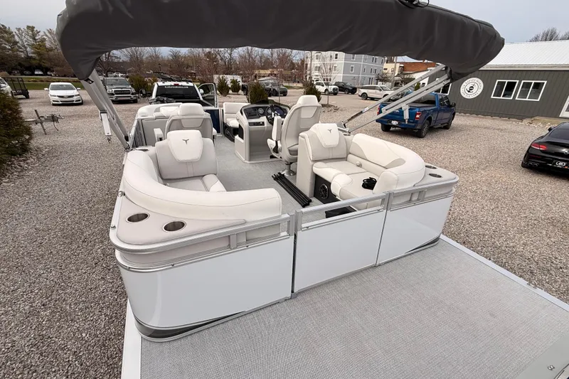 Slide: The Image of 2026 Tahoe Pontoon LTZ Quad Lounger with luxurious seating and canopy in a parking area. - 14