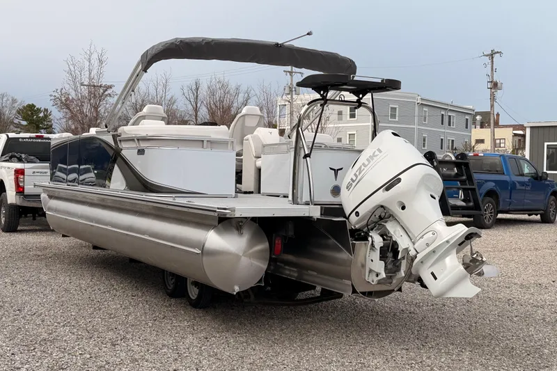 Slide: The Image of 2026 Tahoe Pontoon LTZ Quad Lounger with Suzuki outboard motor on gravel lot. - 6