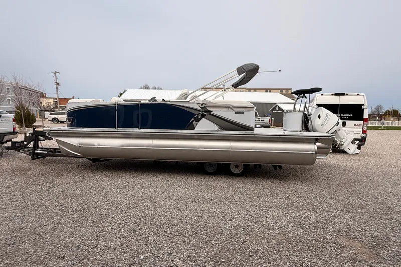 Slide: The Image of 2026 Tahoe Pontoon LTZ Quad Lounger on trailer, parked outdoors. - 7