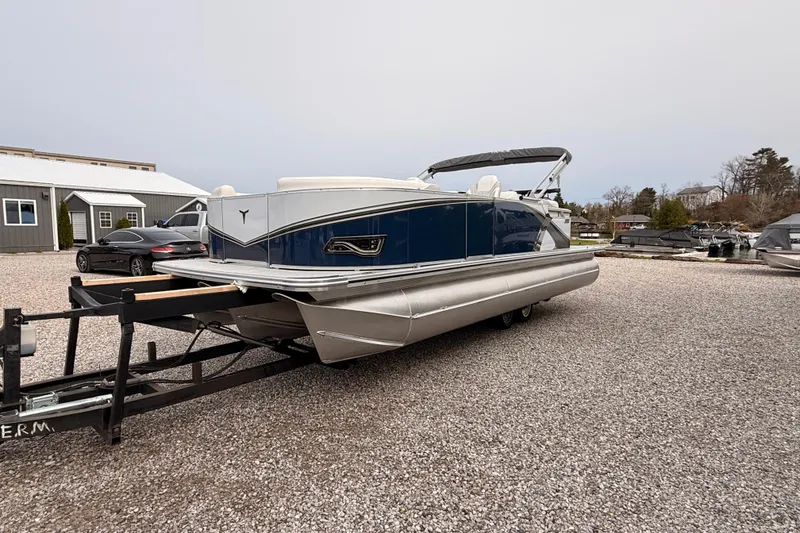 Slide: The Image of 2026 Tahoe Pontoon LTZ Quad Lounger on trailer in gravel lot. - 8