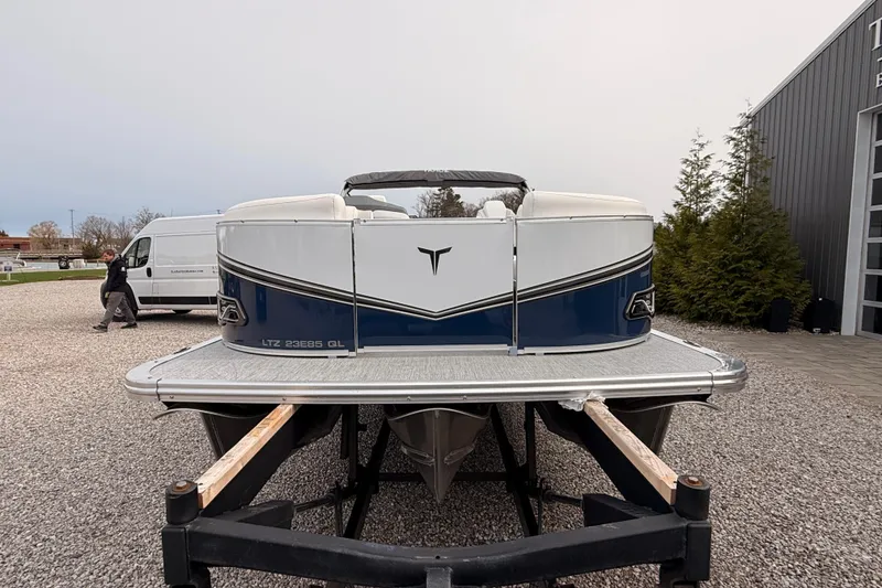 Slide: The Image of 2026 Tahoe Pontoon LTZ Quad Lounger on trailer, parked outdoors near a building. - 9