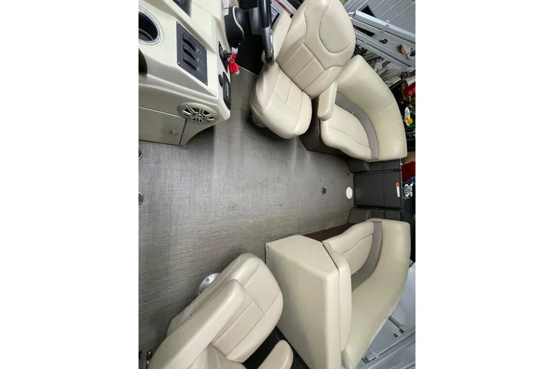 Slide: The Image of 2016 Crest I 220 SLC boat interior with beige seating and control panel. - 10