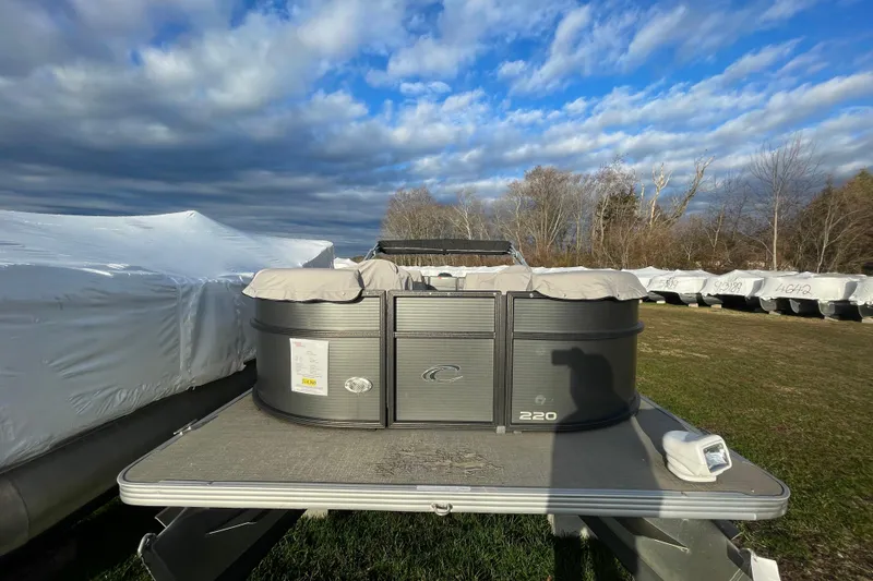 Slide: The Image of 2016 Crest I 220 SLC pontoon boat on display under cloudy sky. - 2