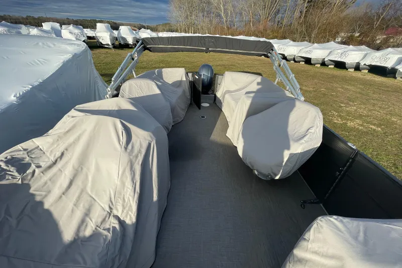 Slide: The Image of 2016 Crest I 220 SLC pontoon boat with covered seats, parked outdoors. - 5