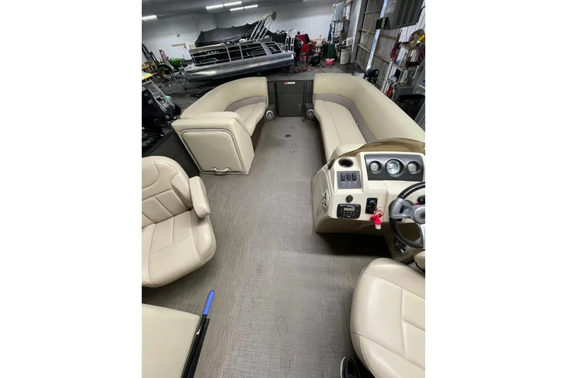 Slide: The Image of 2016 Crest I 220 SLC pontoon boat interior with beige seating and control panel. - 7