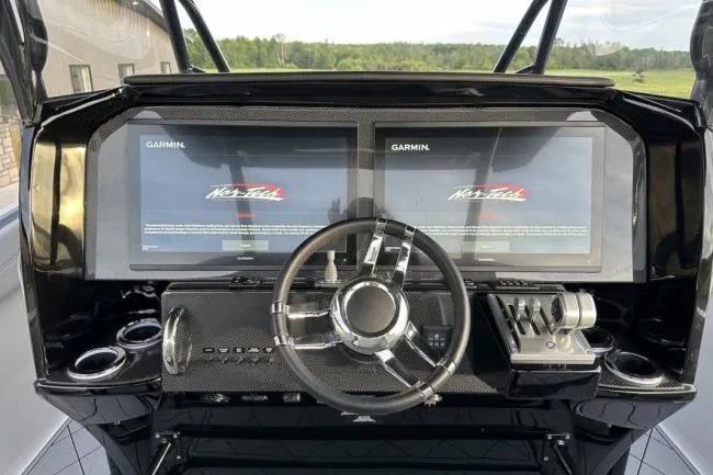 Slide: The Image of 2024 Nor-Tech 340 Sport Center Console dashboard with dual Garmin displays and sleek steering wheel. - 15