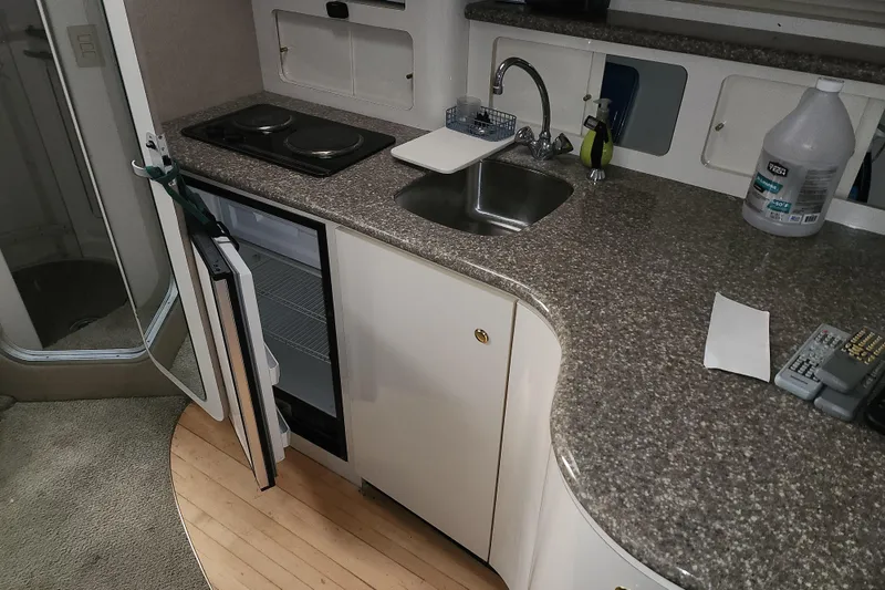 Slide: The Image of 1999 Maxum 3700 SCR yacht kitchen with sink, stove, and open fridge. - 7
