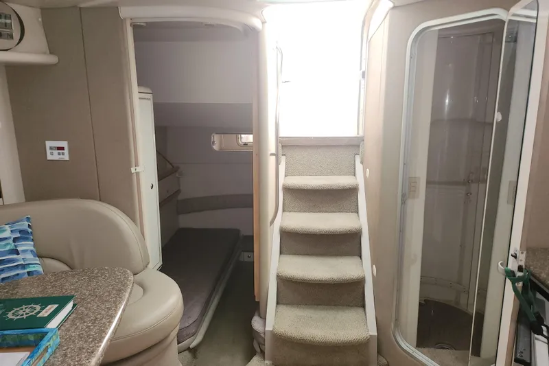 Slide: The Image of 1999 Maxum 3700 SCR yacht interior with stairs, seating, and cabin area. - 9