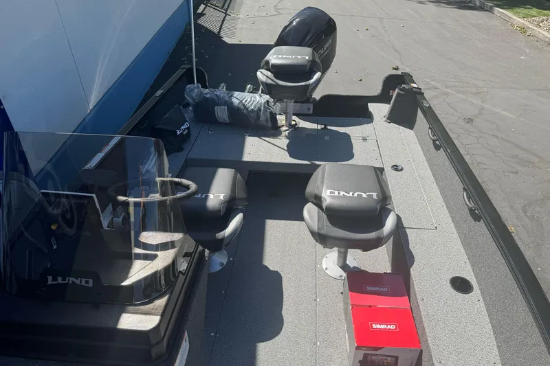 Slide: The Image of 2026 Lund 1650 Rebel XL SS boat interior with seats and steering console. - 16