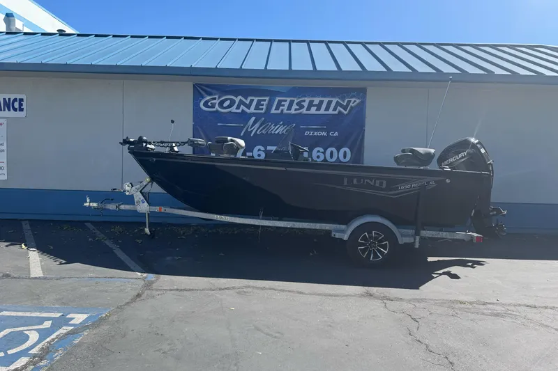 The Image of 2026 Lund 1650 Rebel XL SS boat on trailer outside marine store. - 2