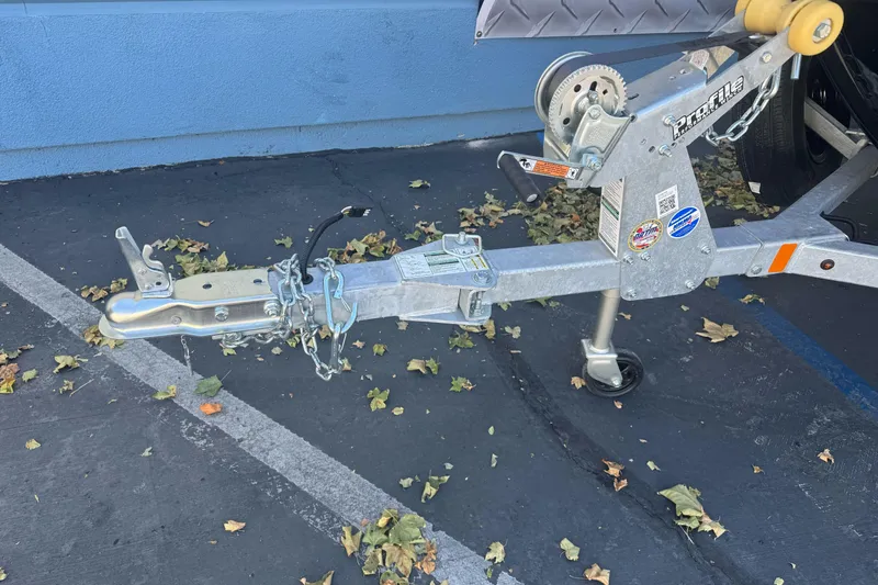 Slide: The Image of Trailer hitch of a 2026 Lund 1650 Rebel XL SS boat, parked on asphalt with fallen leaves. - 4