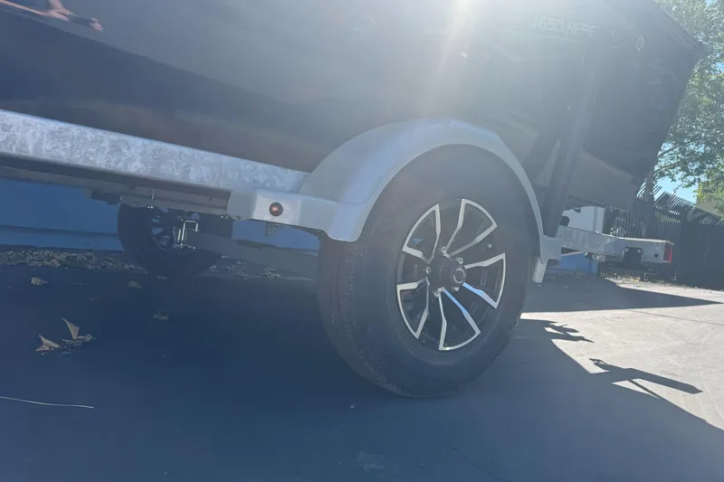 Slide: The Image of 2026 Lund 1650 Rebel XL SS trailer wheel in sunlight. - 6