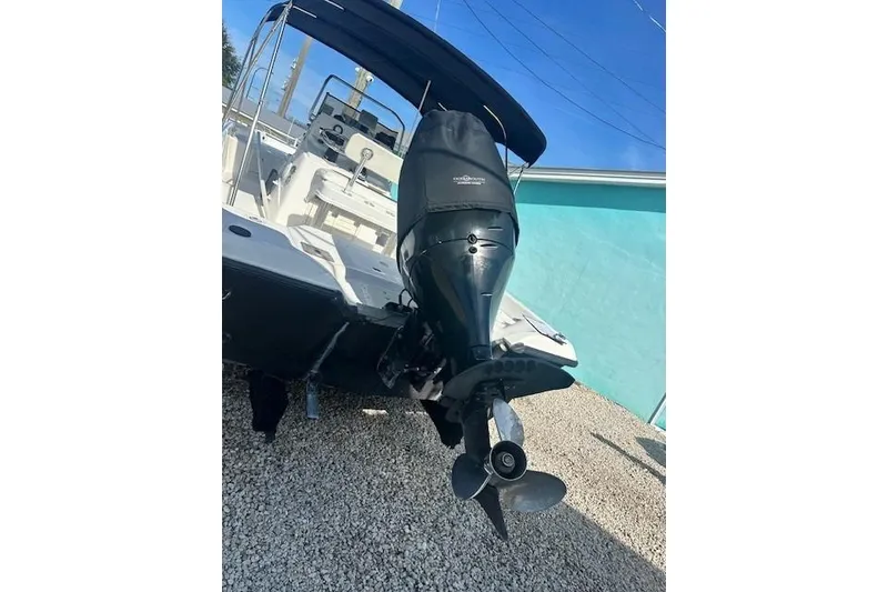 Slide: The Image of 1999 Mako Pro Skiff 21 CC boat with outboard motor, parked on gravel. - 13