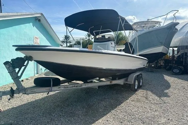 Slide: The Image of 1999 Mako Pro Skiff 21 CC boat on trailer, parked outdoors under a blue sky. - 2
