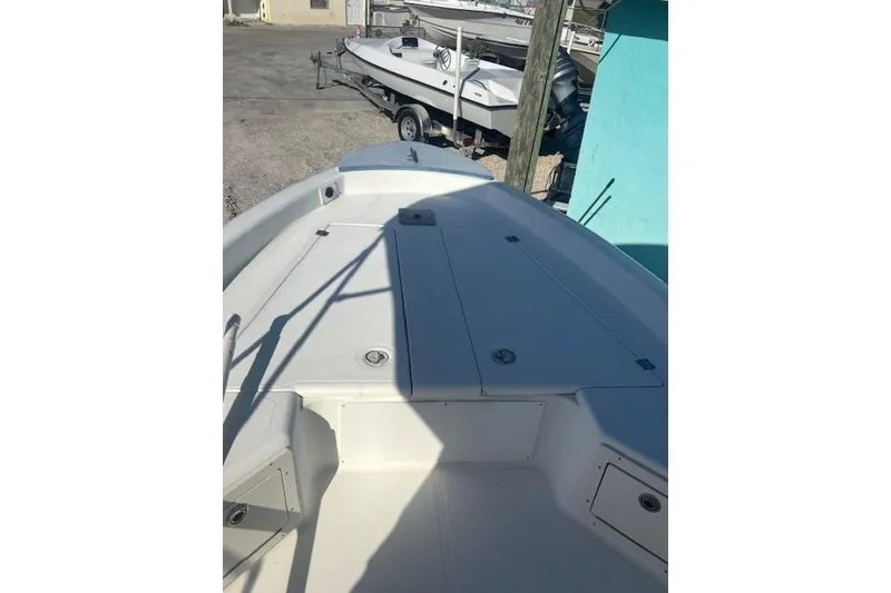 Slide: The Image of 1999 Mako Pro Skiff 21 CC boat deck, featuring storage compartments and clean white surface. - 3