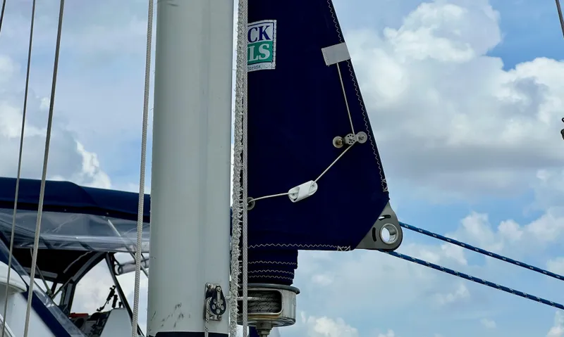 Slide: The Image of Close-up of a 1986 Cape Dory MS300 sailboat mast and sail under a cloudy sky. - 11