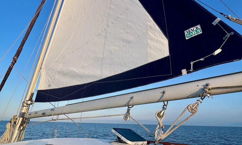 Slide: The Image of Sailing on a 1986 Cape Dory MS300 with white sails against a clear blue sky. - 12