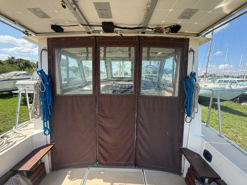 Slide: The Image of 1986 Cape Dory MS300 boat interior with brown canvas enclosure and visible marina background. - 16