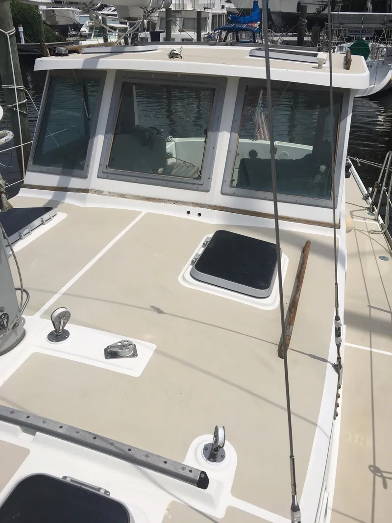 Slide: The Image of 1986 Cape Dory MS300 boat deck with windows and hatches in a marina setting. - 25