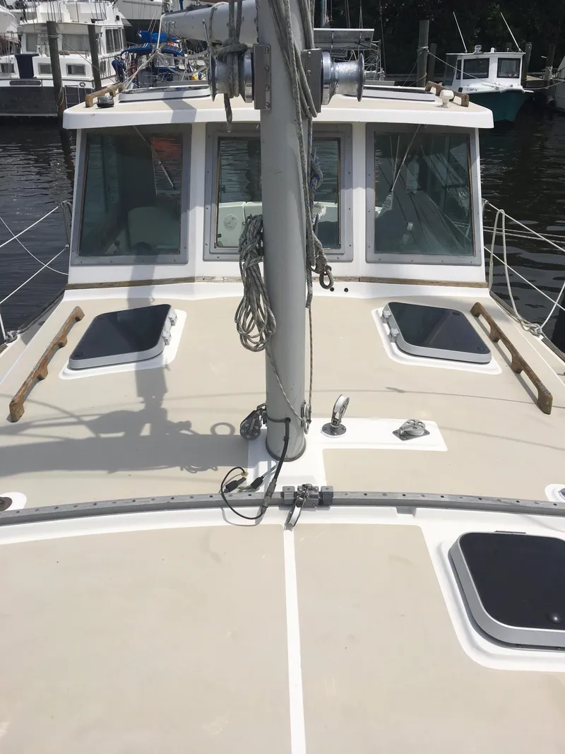 Slide: The Image of 1986 Cape Dory MS300 sailboat deck with hatches and mast, docked in a marina. - 28