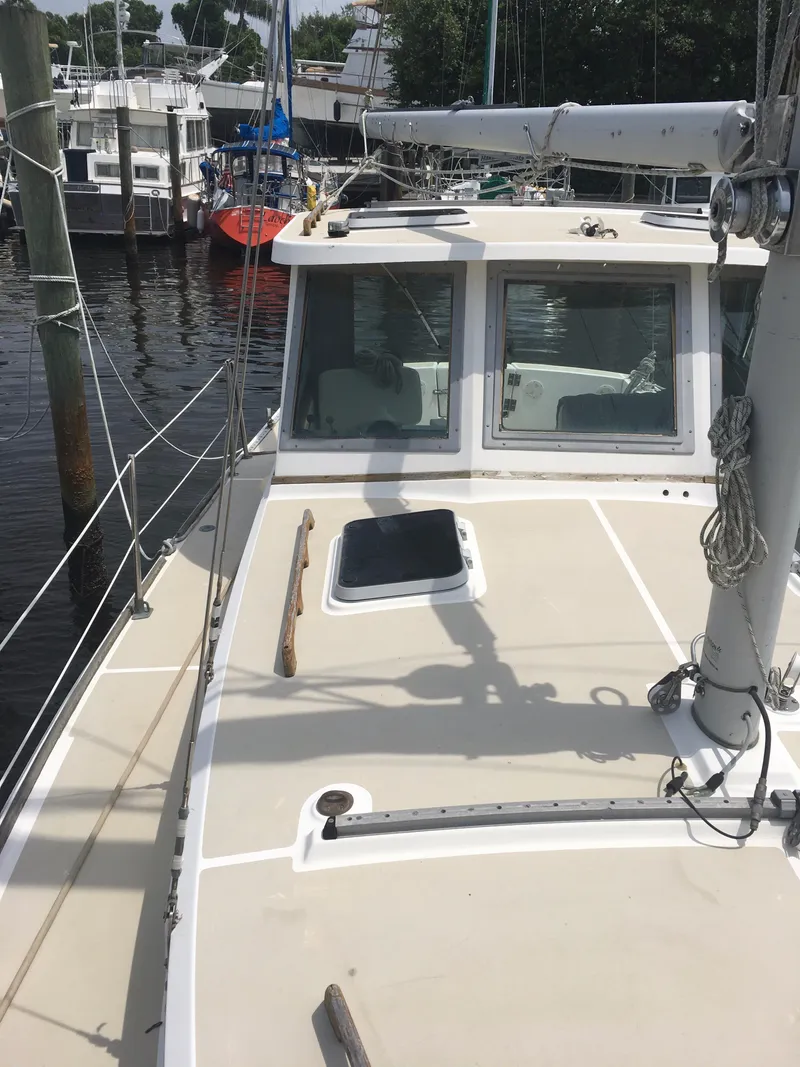 Slide: The Image of 1986 Cape Dory MS300 sailboat docked, showing deck and cabin windows. - 32