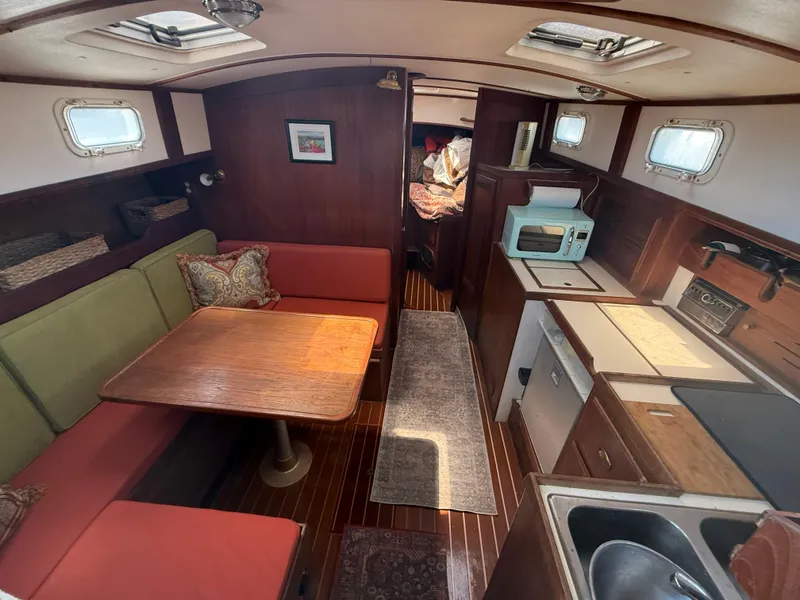 Slide: The Image of 1986 Cape Dory MS300 interior with dining area, kitchenette, and cozy seating. - 34