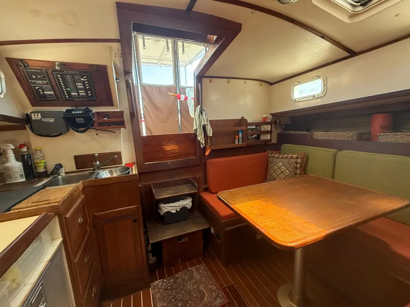 Slide: The Image of Interior of 1986 Cape Dory MS300 sailboat with wooden furnishings and cozy dining area. - 36
