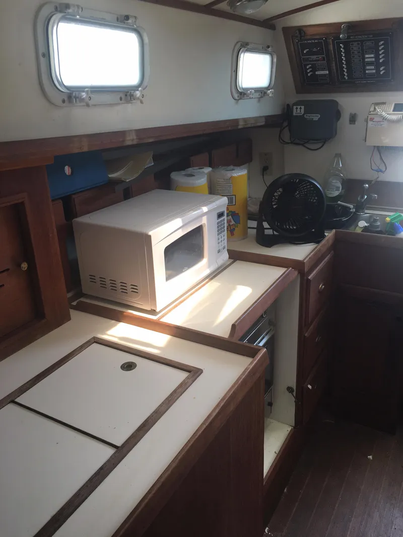 Slide: The Image of 1986 Cape Dory MS300 boat kitchen with microwave, fan, and wooden cabinetry. - 40