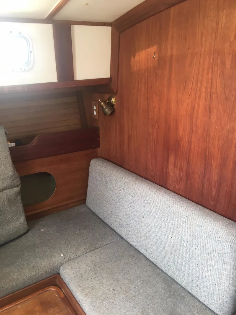 Slide: The Image of Interior of 1986 Cape Dory MS300 sailboat with wooden paneling and gray seating. - 43