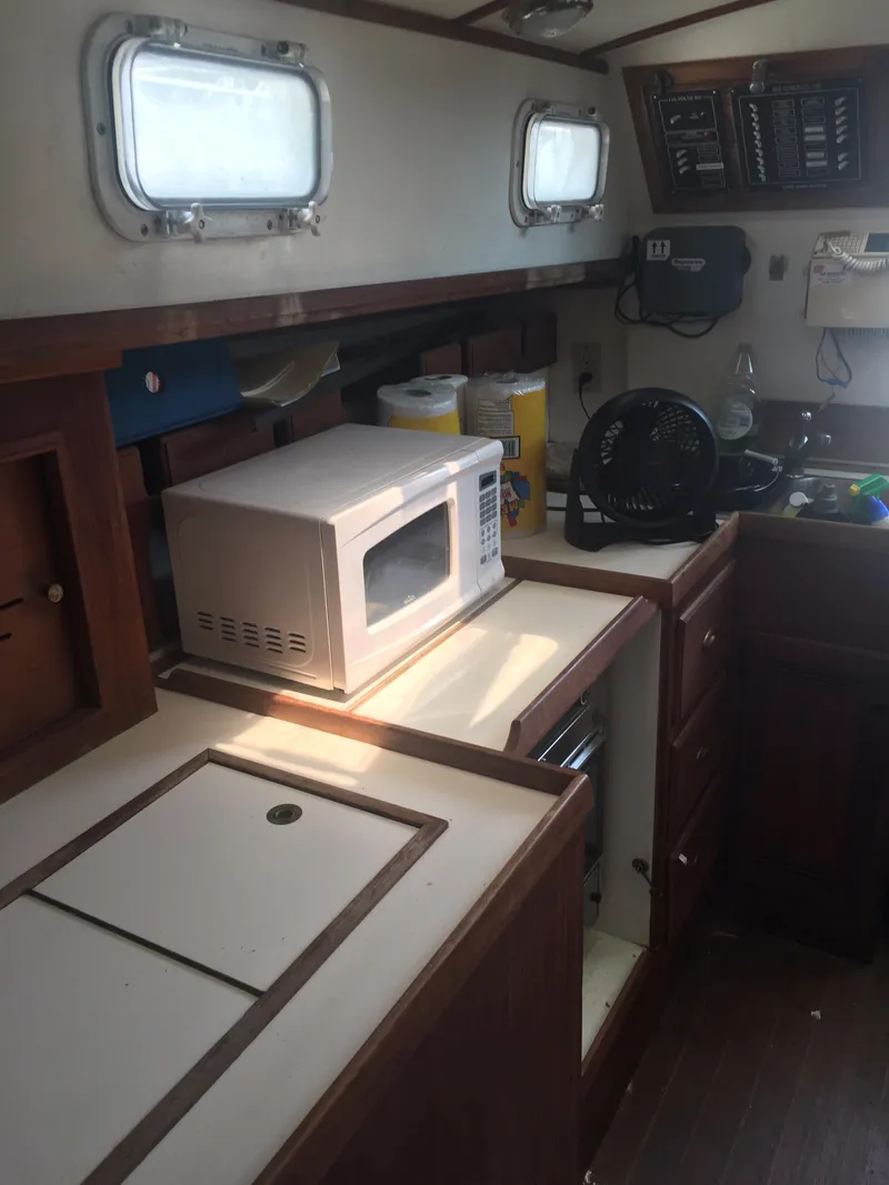 Slide: The Image of 1986 Cape Dory MS300 interior with microwave, fan, and wooden cabinetry. - 46