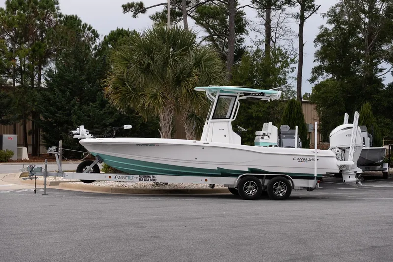 The Image of 2025 Caymas 26 HB boat on trailer, parked outdoors with trees in background. - 1